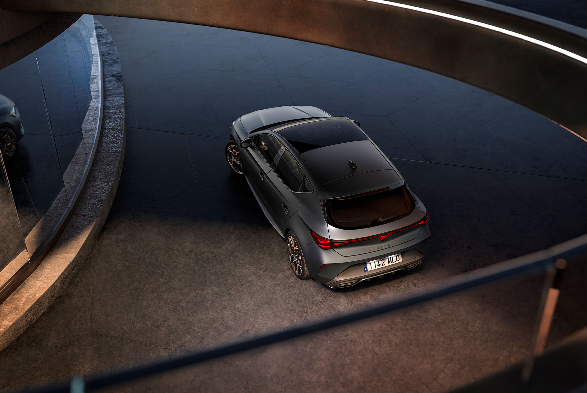 : three quarter bird’s eye view of the new cupra leon 2024 rear, dark setting and mirror reflection of the front.
