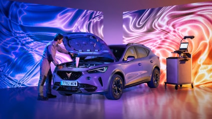 Cupra dealership with cupra born electric vehicle being serviced by team member.