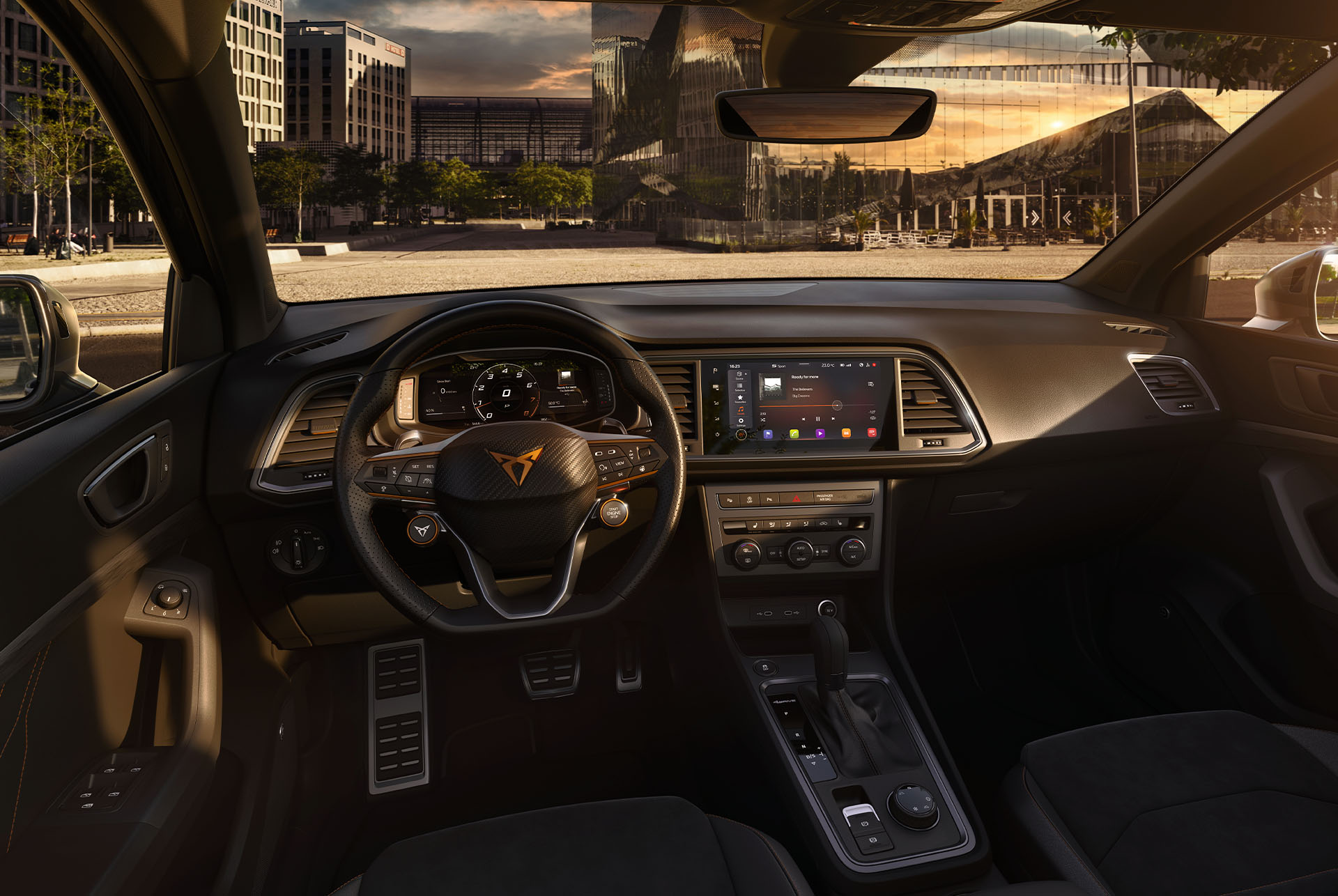 Interior view of the CUPRA Ateca SUV, showcasing the steering wheel with satellite buttons for engine start and drive profile selection. Paddle shifters behind the wheel offer convenient gear shifting. 