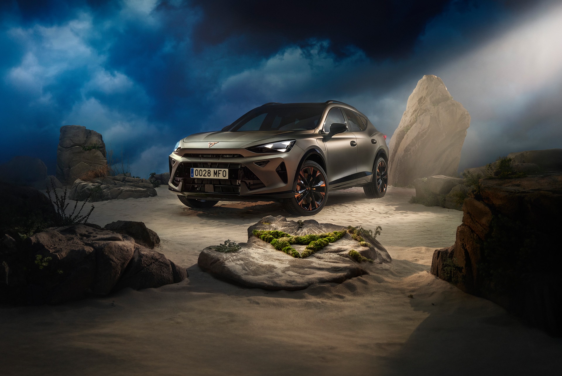 CUPRA Formentor technology. The car showcases copper accent wheels, and is parked in an outdoors setting, on a sandy and rocky background at night.