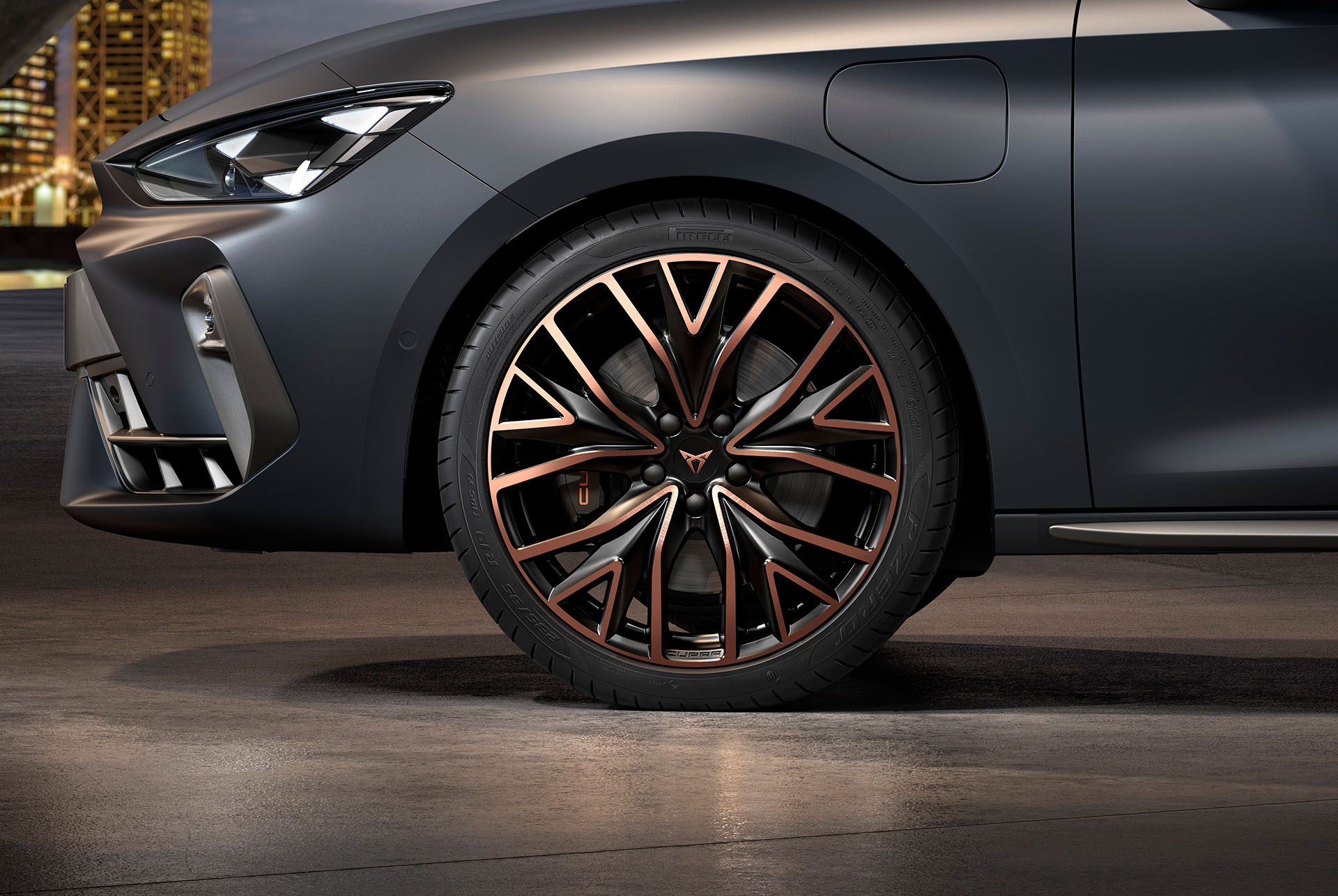 front side view of left mstral copper forged wheels in copper and black for the new cupra leon sportstourer 2024, tyres, signature headlights and grey body