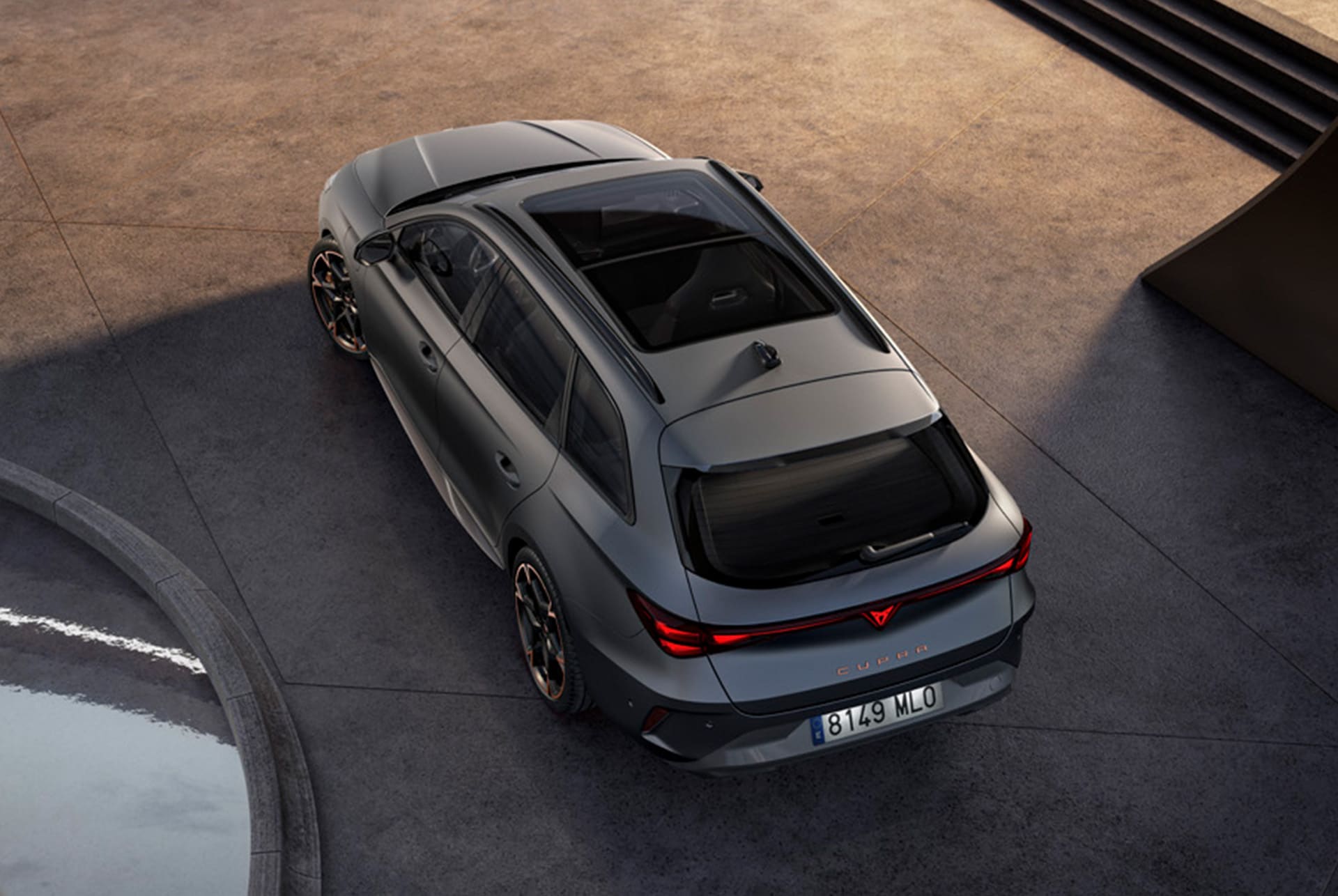 This image features a bird’s-eye rear view of the CUPRA Leon Sportstourer in sleek matte grey. Its sporty and refined design is accentuated by the natural light, showcasing its modern and dynamic styling.