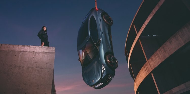 Cupra tavascan hanging at  concrete setting with sky backdrop and  model