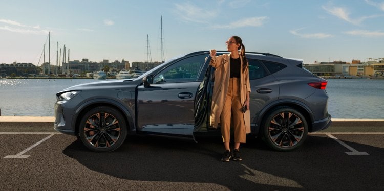 Woman exiting the cupra  tavascan obtained through classical credit leasing with no balloon payment.